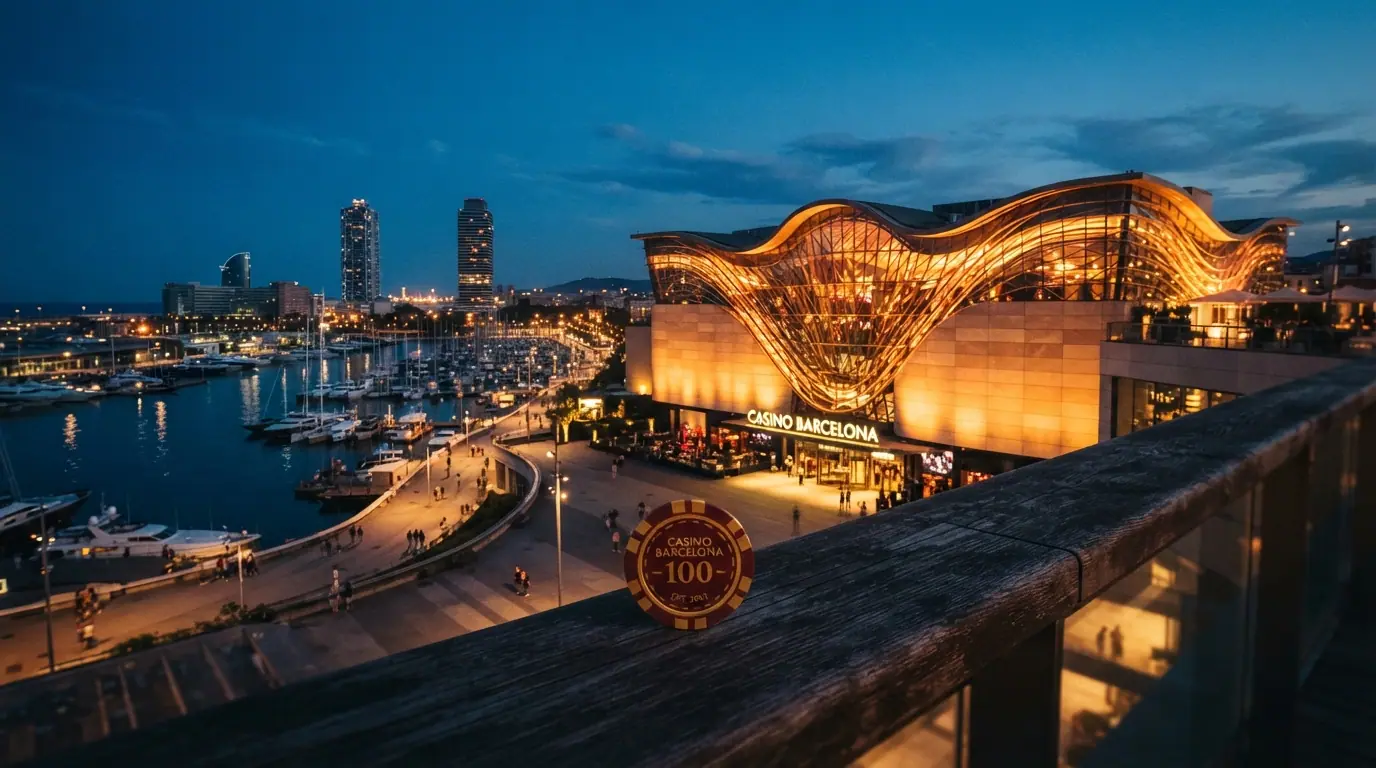Fachada nocturna iluminada del edificio de Casino Barcelona en Port Olímpic, con el skyline marítimo de Barcelona al fondo